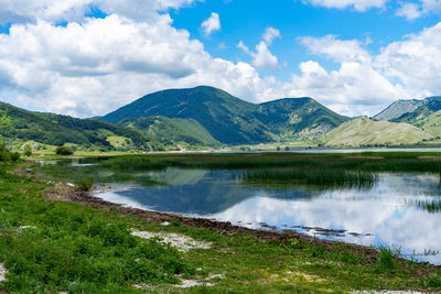 Scenic view of lake and mountains against sky