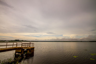 Pier over lake against sky during sunset