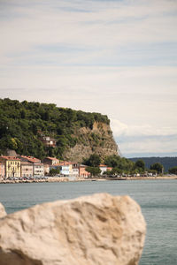 Scenic view of sea by buildings against sky