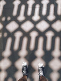 Low section of person standing on tiled floor