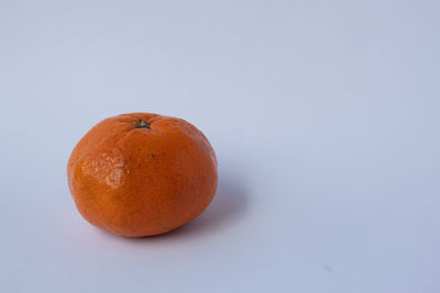 Close-up of orange apple against white background