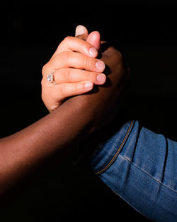 Close-up of hands against black background