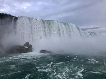 Scenic view of waterfall against sky