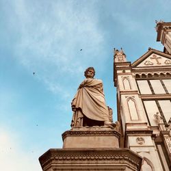 Low angle view of statue against building against sky