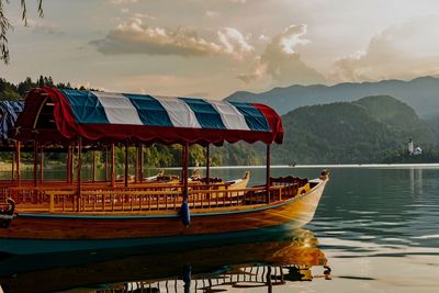 Boat moored on lake against sky