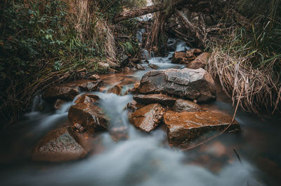 View of stream flowing through rocks