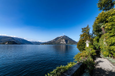 Scenic view of sea and mountains against blue sky