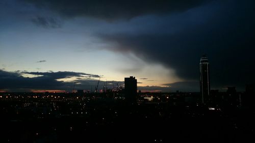 Illuminated cityscape against sky at dusk