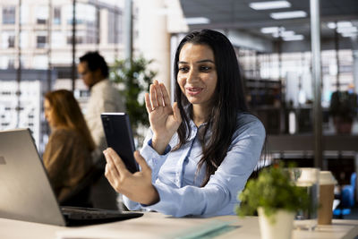 Businesswoman using mobile phone while sitting in cafe