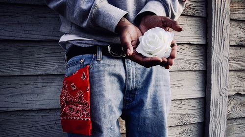 Midsection of man holding ice cream while standing on wood