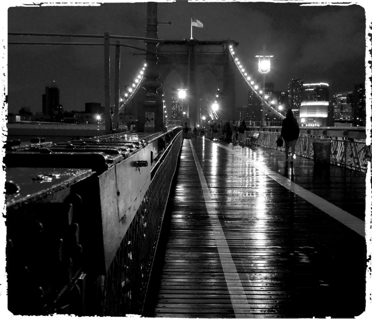 ILLUMINATED BRIDGE OVER STREET AT NIGHT