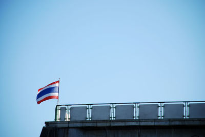 Low angle view of flag against clear blue sky