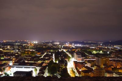 High angle view of illuminated cityscape against sky at night