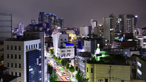 Illuminated buildings in city against sky at night