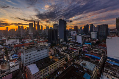 Aerial view of buildings in city against sky during sunset