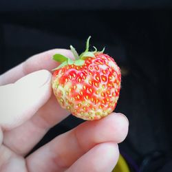 Close-up of hand holding strawberry