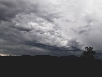 Silhouette of mountain against cloudy sky