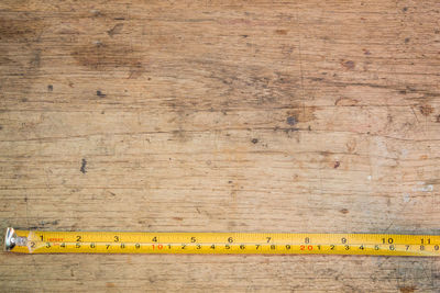 Directly above shot of tape measure on wooden table