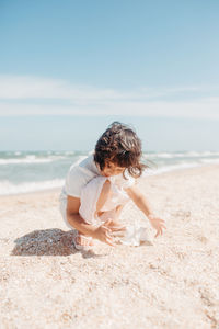 Boy on beach against sky