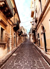 Empty alley amidst buildings in city