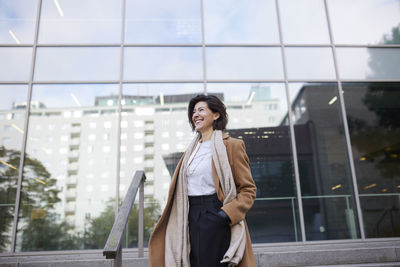 Smiling businesswoman outside office building