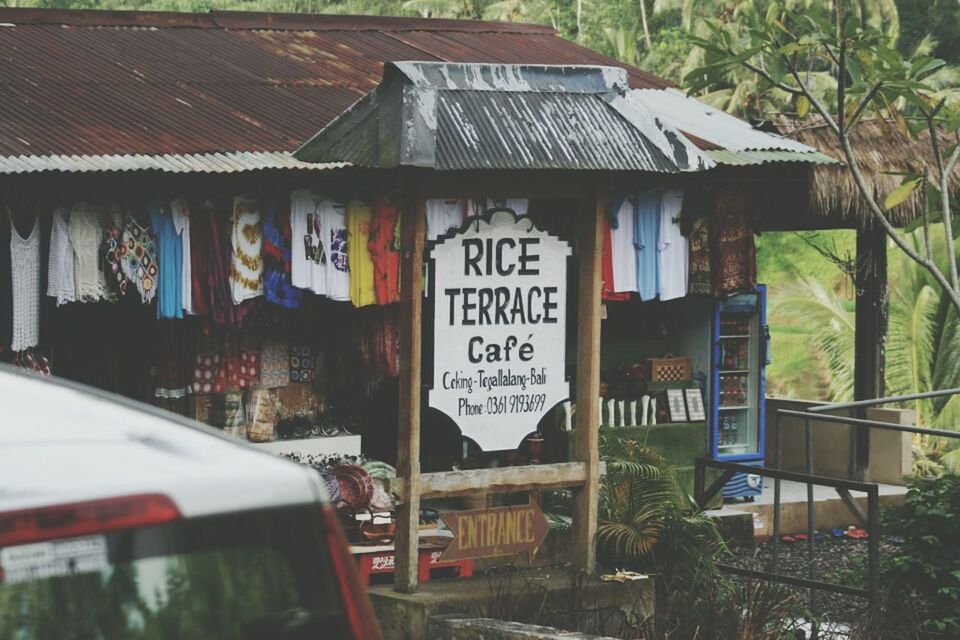 text, western script, communication, built structure, architecture, building exterior, non-western script, information sign, graffiti, tree, sign, city, information, capital letter, day, house, outdoors, no people, window, building