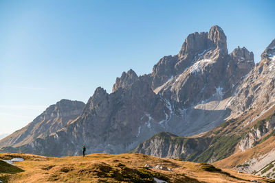 Woman hiking on footpath in alpine landscape in autumn, bischofsmütze, filzmoos, austria