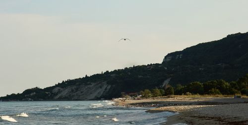 Scenic view of sea and mountains against clear sky