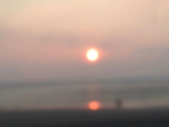 Defocused image of silhouette landscape against sky during sunset