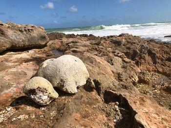 Rock formation on beach against sky