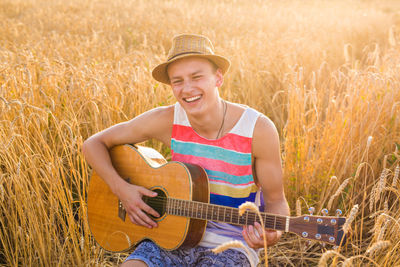 Smiling young man playing guitar