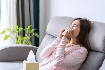 Young woman sitting on sofa at home