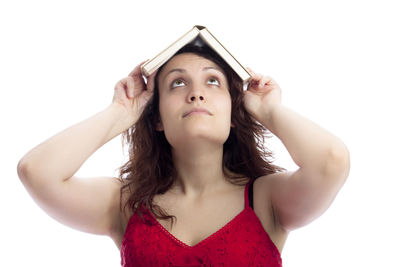 Portrait of young woman looking up against white background