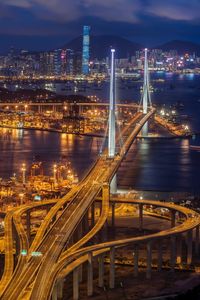 Illuminated bridge over river at night