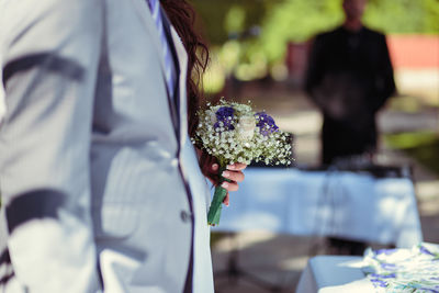 Cropped hand of bride holding bouquet during wedding