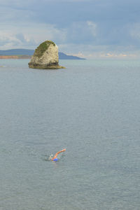 Scenic view of rocks in sea against sky