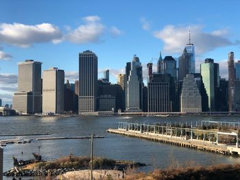 River amidst buildings in city against sky