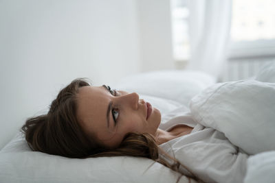 Close-up of woman relaxing on bed at home