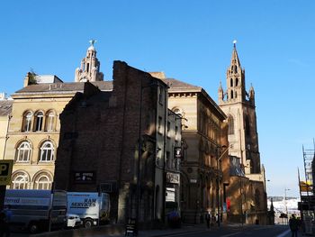 Buildings in city against clear blue sky