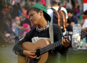 Man playing guitar in city