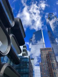 Low angle view of modern buildings against blue sky