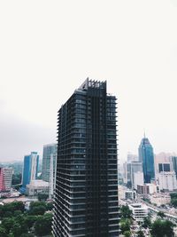 Buildings in city against clear sky