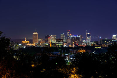 Illuminated cityscape against sky at night