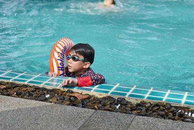 Portrait of cute boy swimming in pool