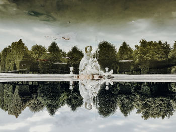 Reflection of statue and trees in lake