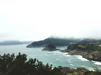 Scenic view of sea and mountains against sky