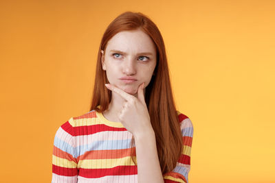 Portrait of woman against yellow background