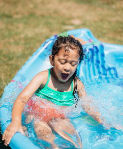 Cute girl enjoying at wading pool outdoors