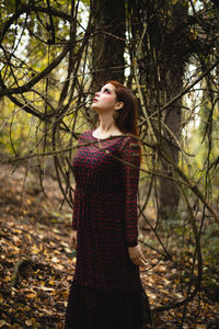 Young woman looking up in forest