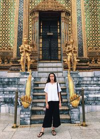 Portrait of woman standing against building